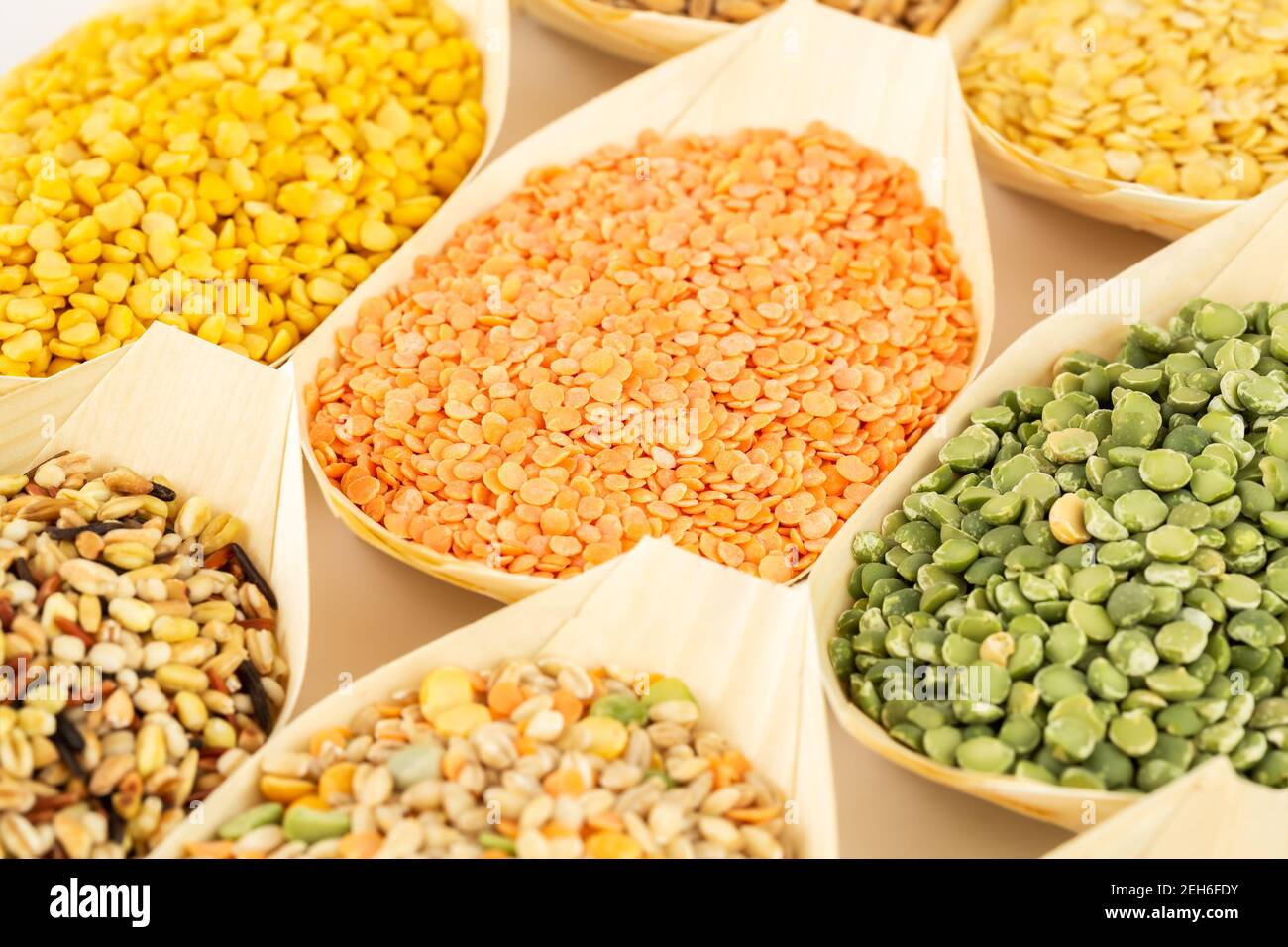 The collection of different groats in the bamboo bowls. Wheat, peas, rice and lentils. Stock Photo
