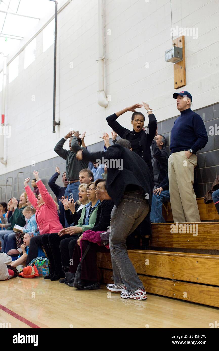 President Barack Obama, First Lady Michelle Obama, Vice President Joe Biden, and Dr. Jill Biden, react while watching Sasha Obama and Maisy Biden play in a basketball game in Chevy Chase, Md., Feb. 27, 2010. Stock Photo