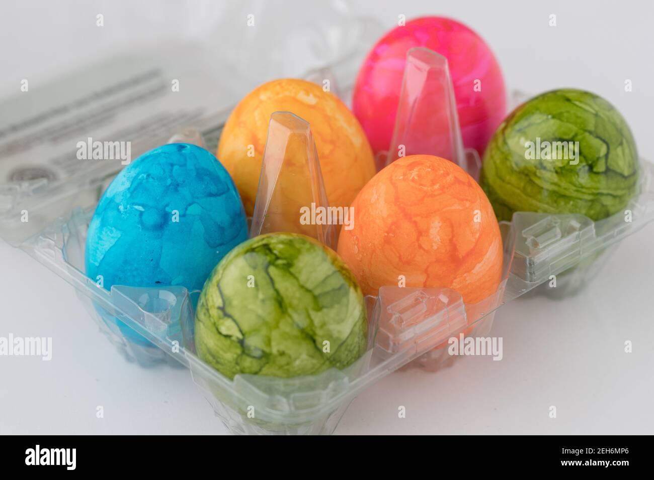 six colorful easter eggs in a box of plastic bought in a supermarket Stock Photo