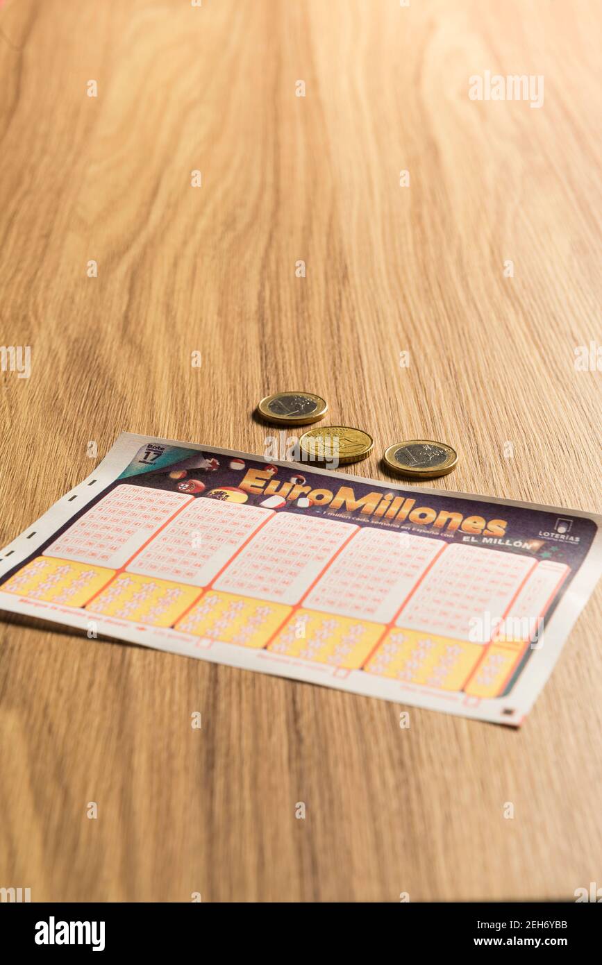 Spain. February 18, 2021. EuroMillions ticket and euro coins on a table. Euromillions in Spain is managed by the entity SELAE, the Spanish acronym for Stock Photo