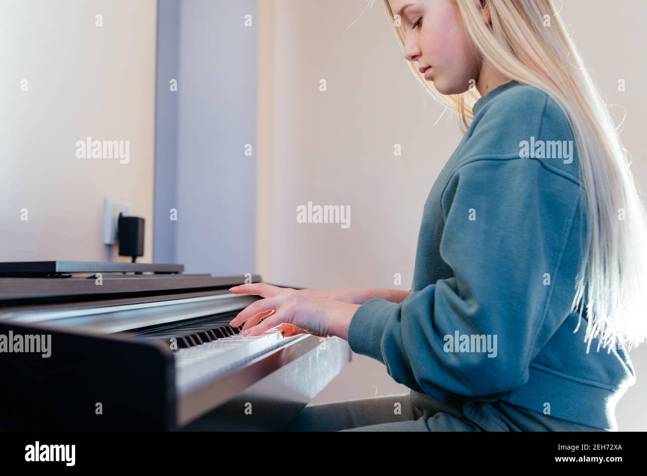 Little girl learning to play electric piano Stock Photo Alamy