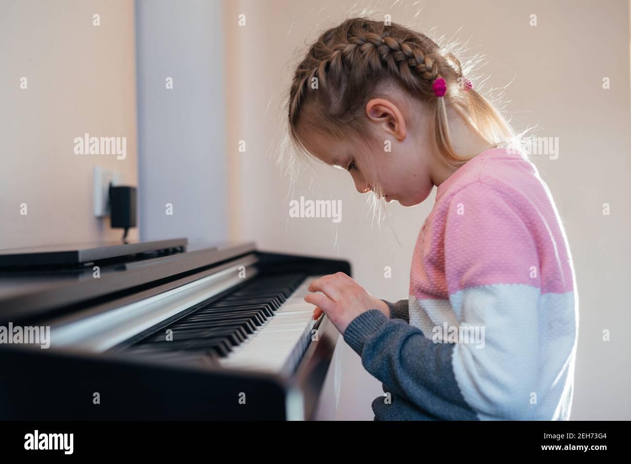 Little girl learning to play electric piano Stock Photo Alamy