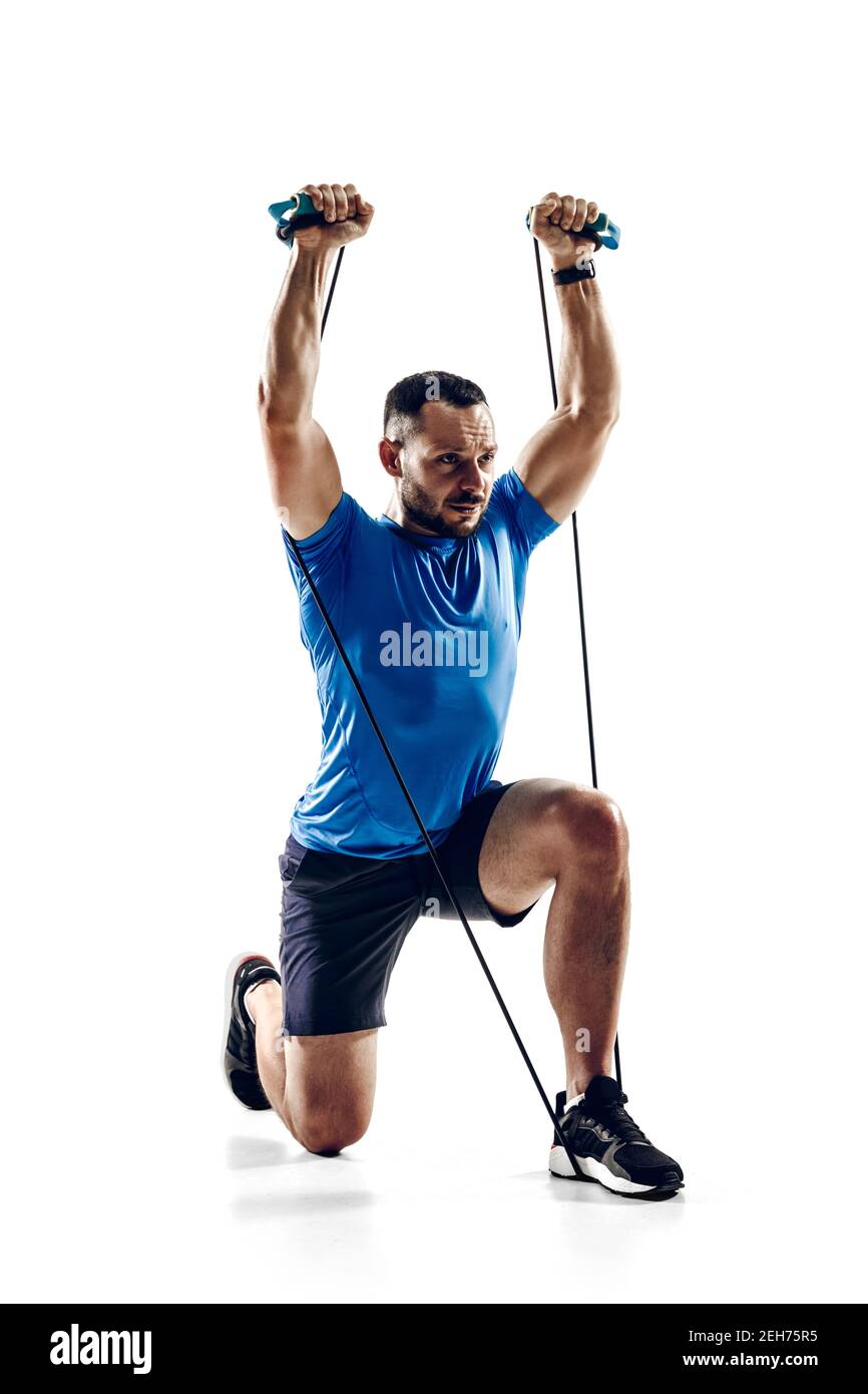 Stretching. Caucasian professional male athlete, runner training isolated  on white studio background. Muscular, sportive man. Concept of action,  motion, youth, healthy lifestyle. Copyspace for ad Stock Photo - Alamy