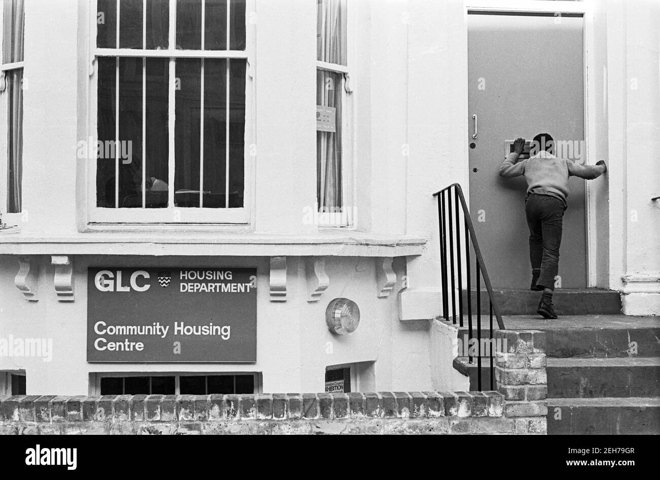 UK, West London, Notting Hill, 1973. Rundown & dilapidated large four-story houses are starting to be restored and redecorated. Greater London Council Housing Department - Community Housing Centre for local people. Stock Photo