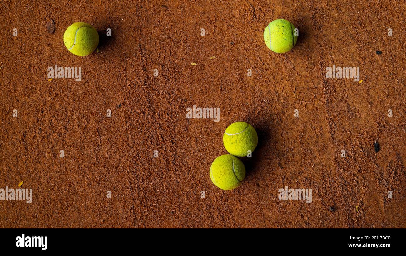 Group of tennis balls on the orange ground in a tennis court Stock