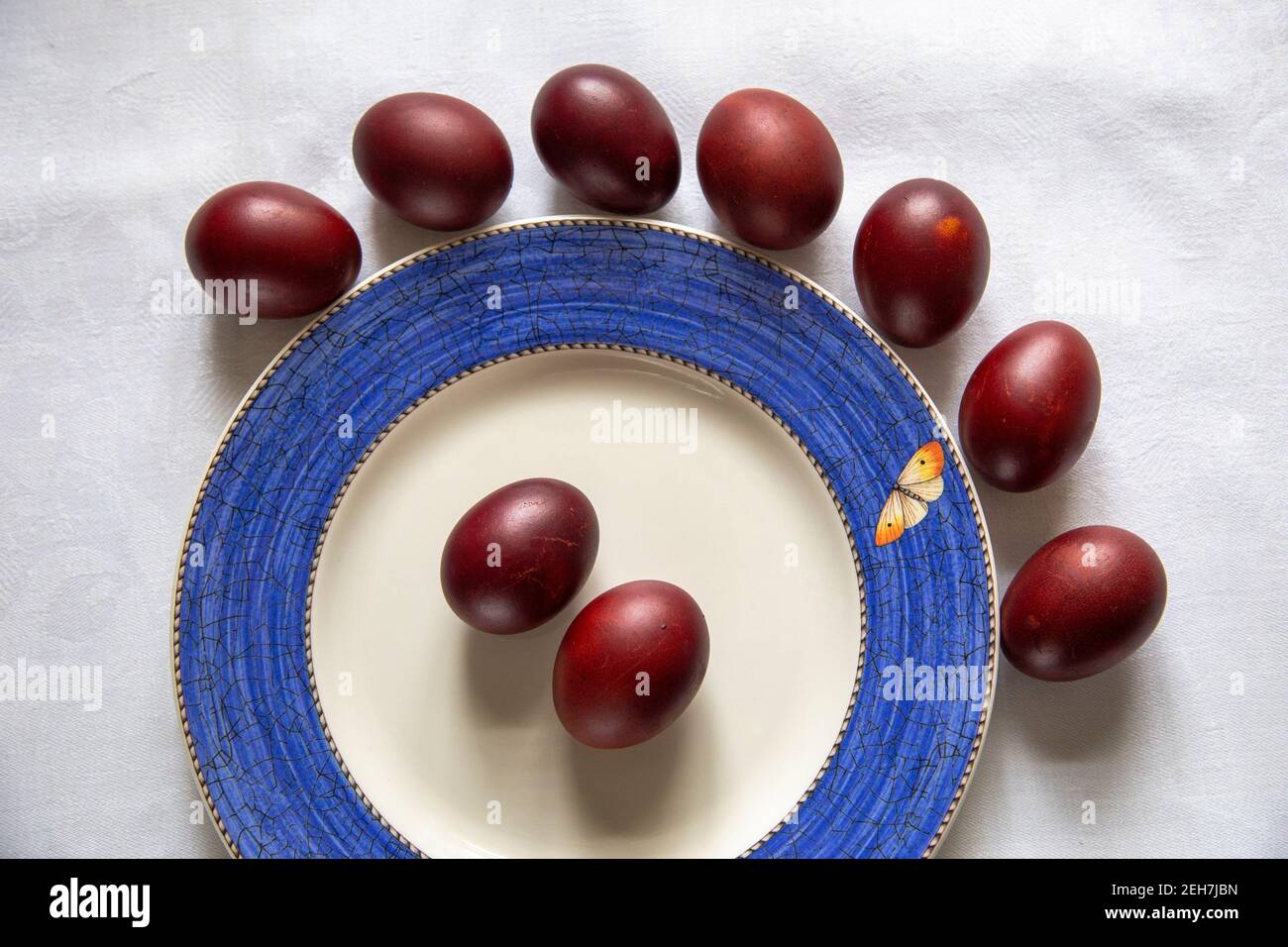 a table with Easter colored eggs on white table cloth Stock Photo
