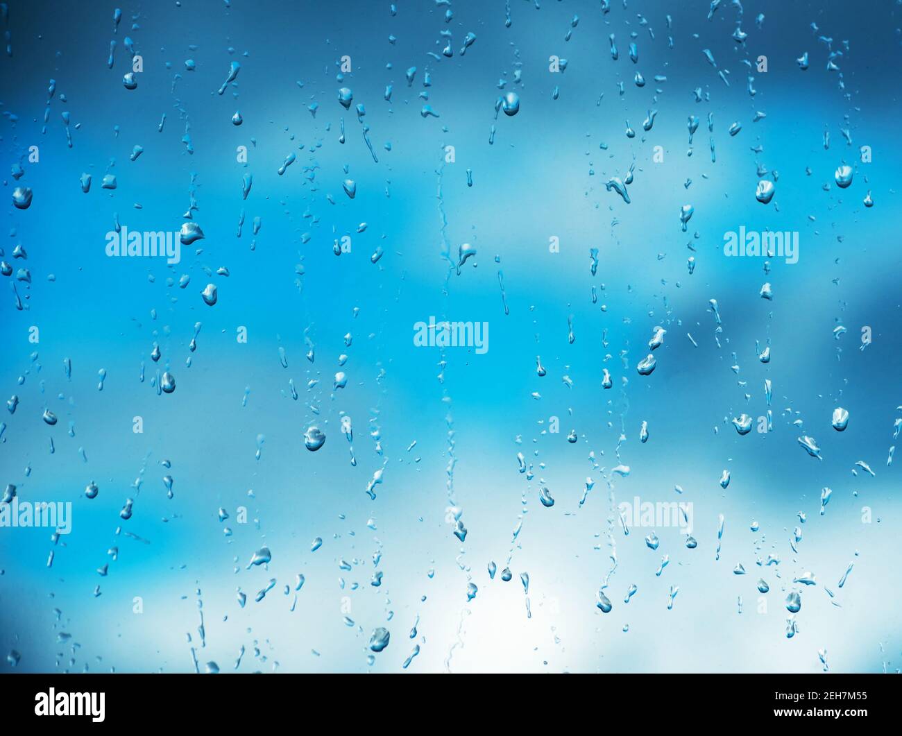 Rain drops on surface of the window glass with cloud background ...