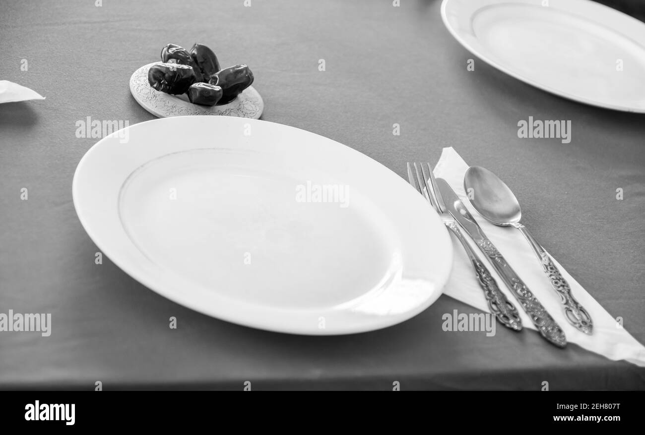 Table with empty plates being prepared for ramadan iftar Stock Photo