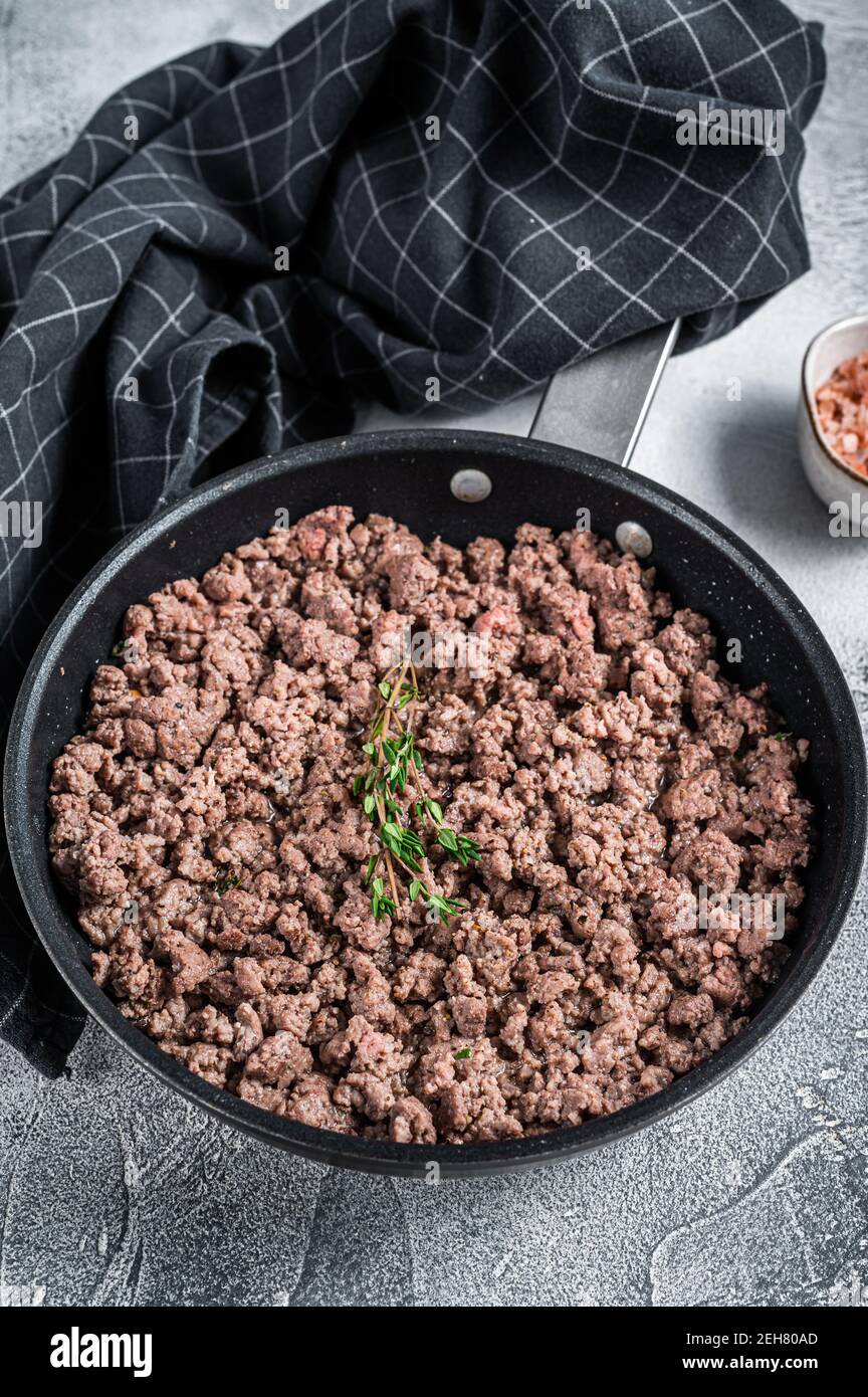 Fried mince beef and lamb meat in a pan with herbs. White background