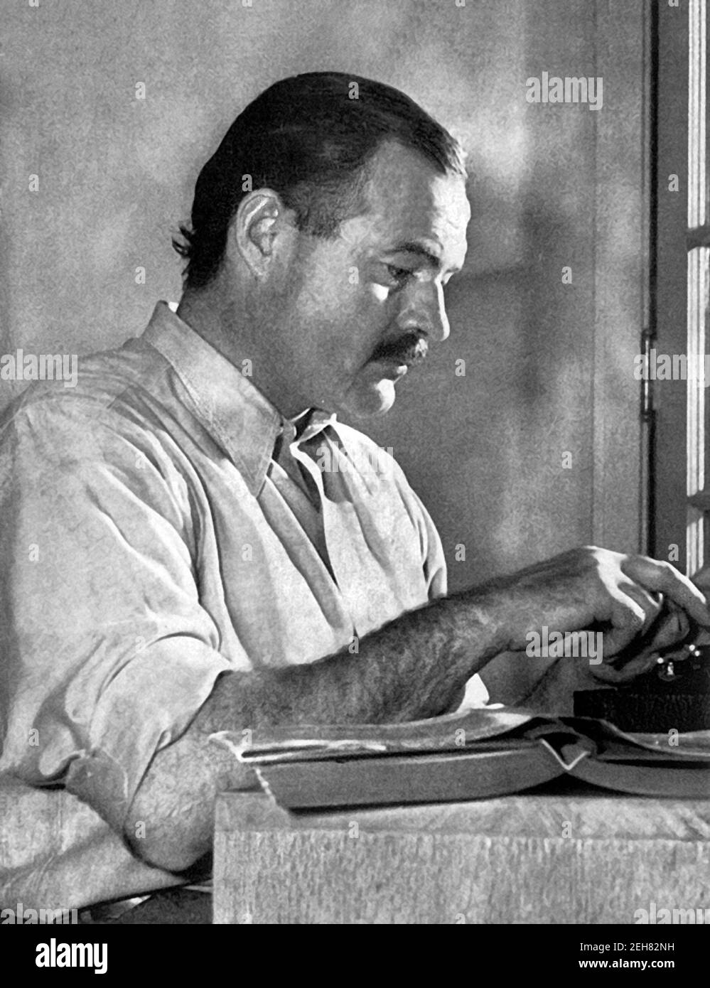 Ernest Hemingway. Portrait of the American writer, Ernest Miller Hemingway (1899-1961) at his typewriter in 1939. Stock Photo