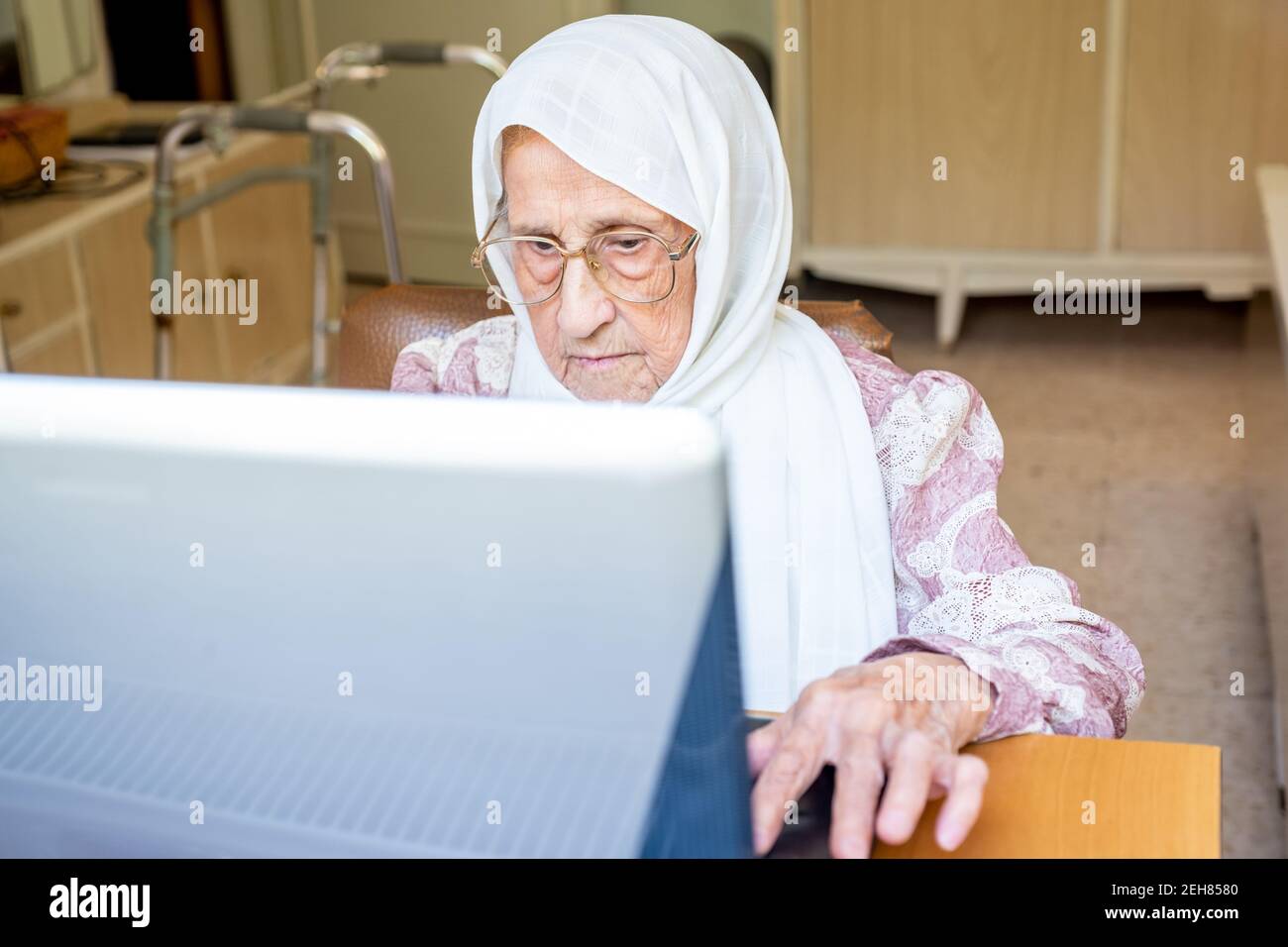 Old woman using laptop for working and communicating Stock Photo