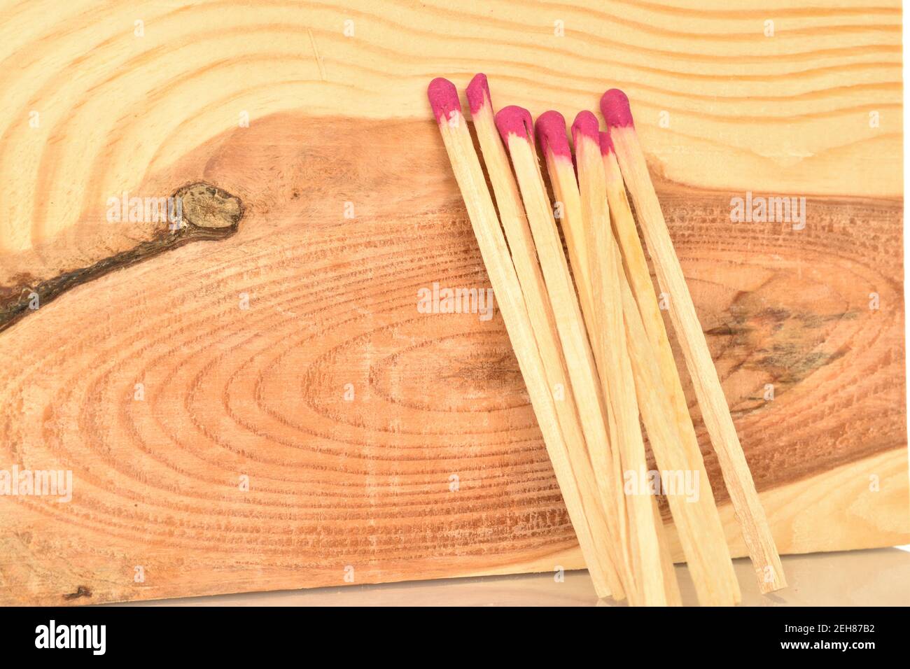 Several wooden matches on a natural wood background. Stock Photo