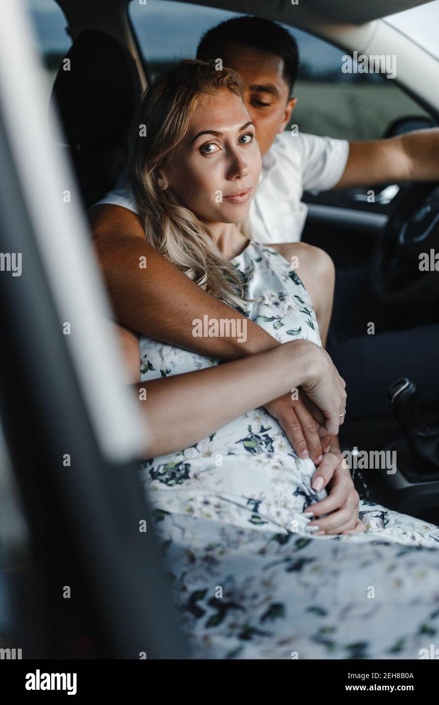 Happy couple in a car. Embracing man and woman in a car Stock Photo