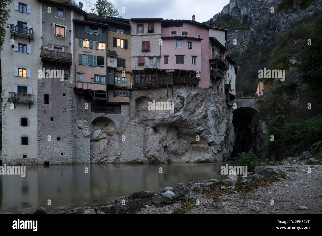 View along the river of one of the characteristic suspended dwellings of Pont-en-Royans, in the Auvergne-Rhone-Alps region, during the twilight. Stock Photo