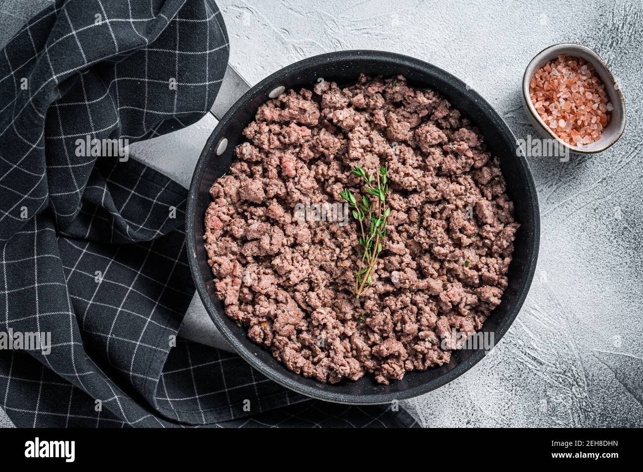 Fried mince beef and lamb meat in a pan with herbs. White background