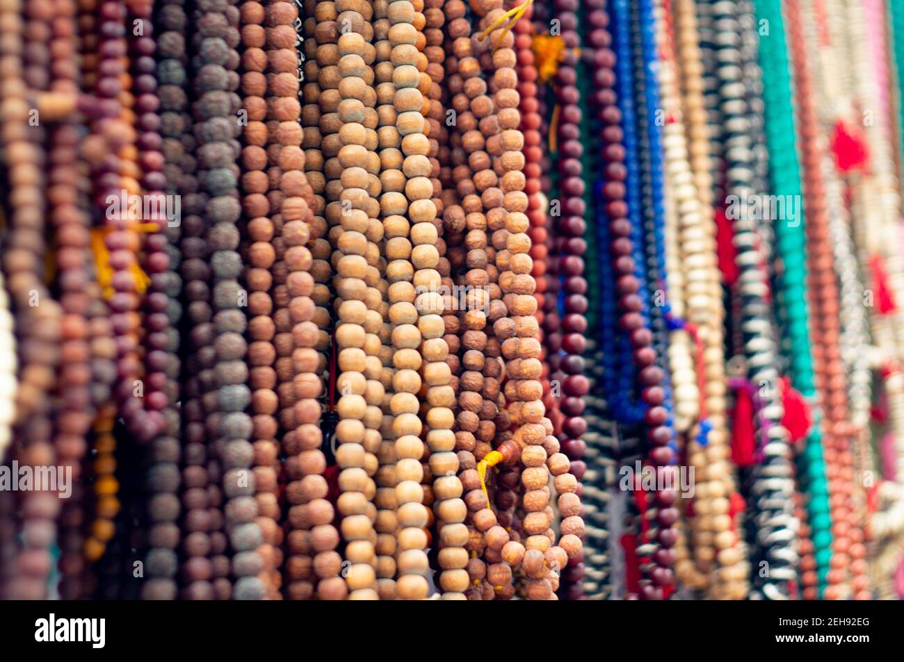 wooden prayer worry beads on string used as a way to reduce stress and relax sold in an open shop as a tourist attraction near hinduism buddhism Stock Photo