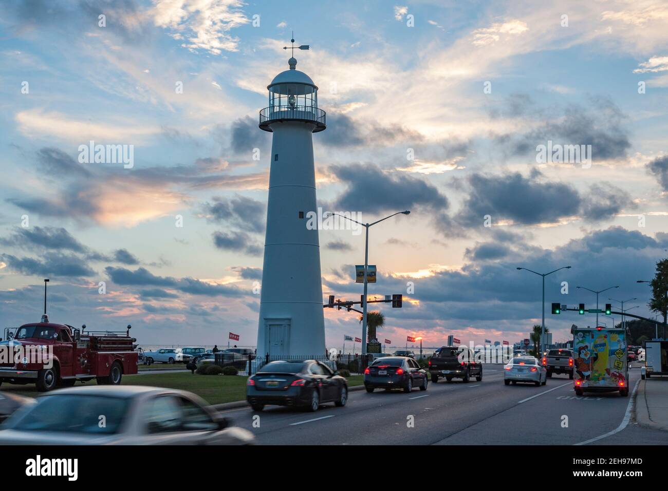 Traffic driving past the Biloxi Lighthouse at sunset on Highway 90 in Biloxi, Mississippi Stock Photo