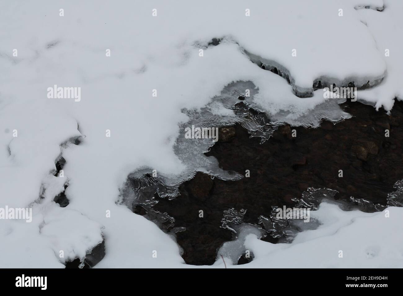 Melted area, in frozen creek Stock Photo