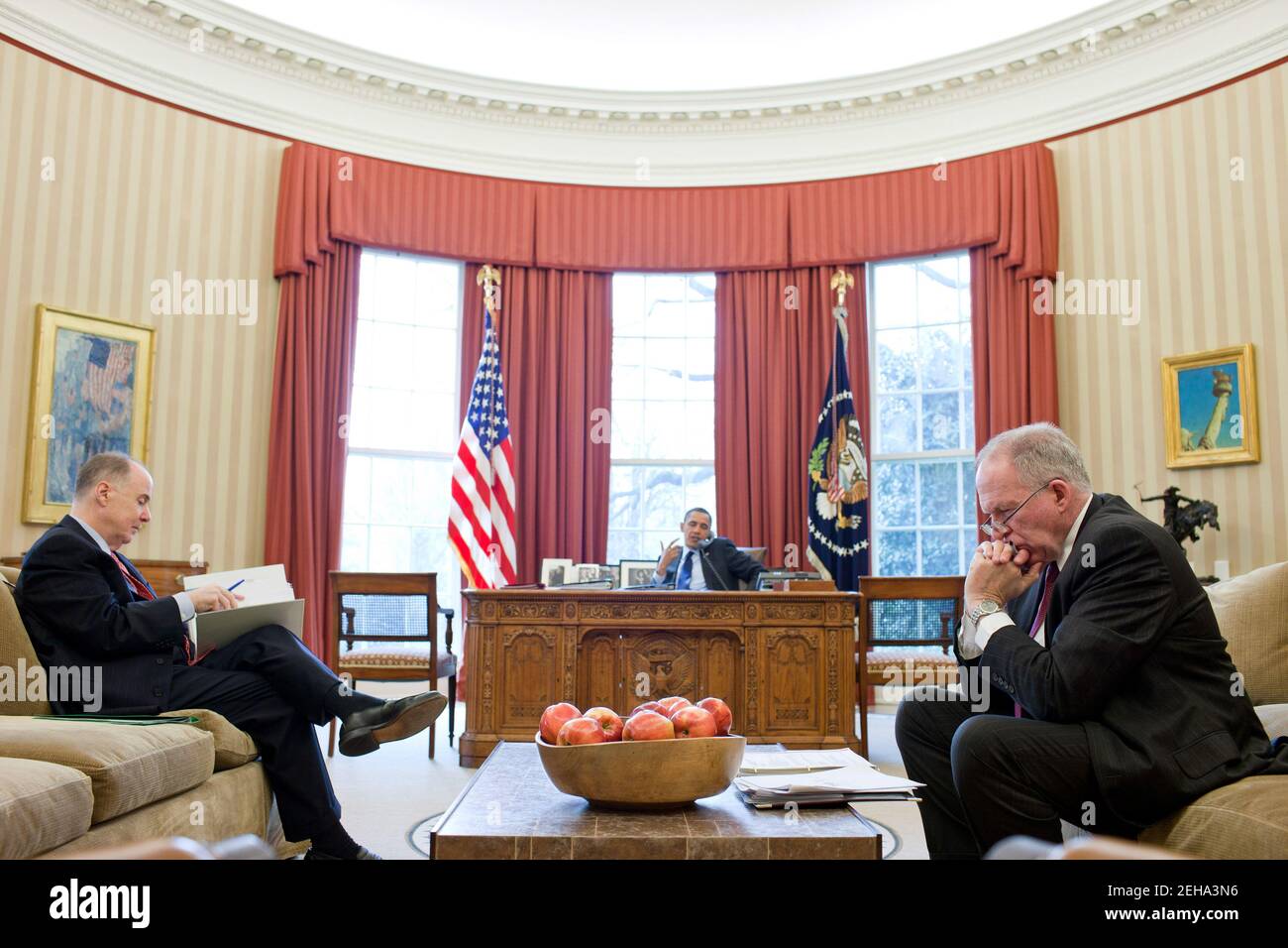 National Security Advisor Tom Donilon and John Brennan, Assistant to the President for Homeland Security and Counterterrorism, right, listen as President Barack Obama talks on the phone in the Oval Office, March 16, 2011. Stock Photo