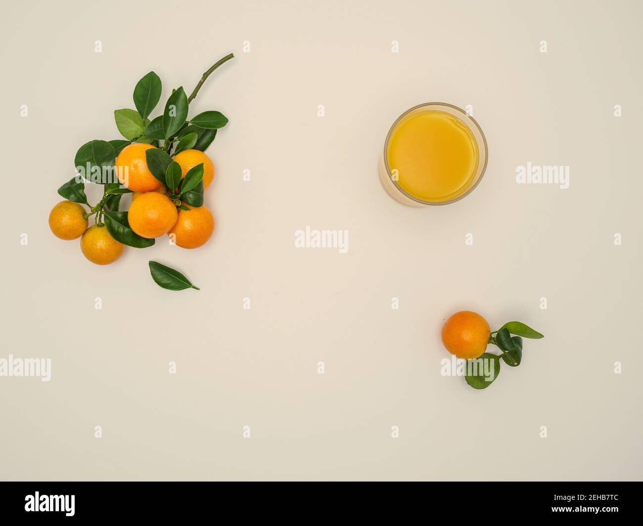 https://c8.alamy.com/comp/2EHB7TC/fresh-clementines-citrus-clementina-with-green-leaves-and-fresh-juice-on-beige-background-hybrid-of-small-sized-tangerines-overhead-copy-space-2EHB7TC.jpg