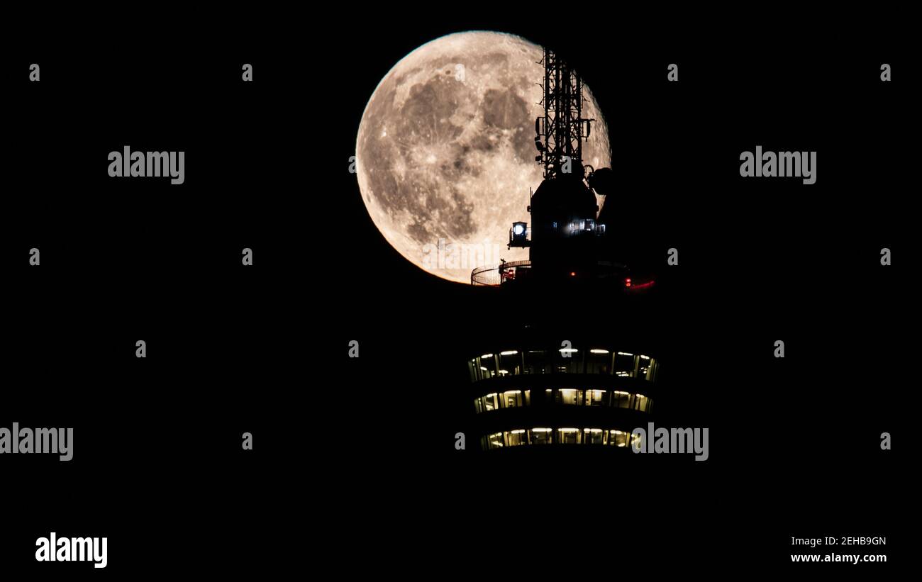 Stuttgart, Germany, August 4, 2020 - the rising moon behind the Stuttgart TV tower. Details of the antenna aginst the bright moon, nobody on the tower Stock Photo
