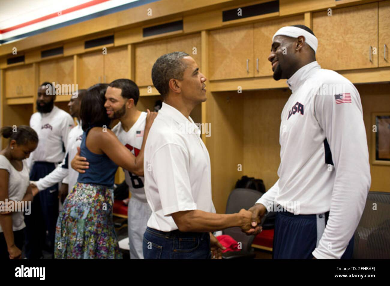 President Barack Obama talks with LeBron James as First Lady Michelle Obama hugs Deron Williams during their greet with members of the U.S. Men's Olympic basketball team at halftime of their game against Brazil at the Verizon Center in Washington, D.C., July 16, 2012. Stock Photo