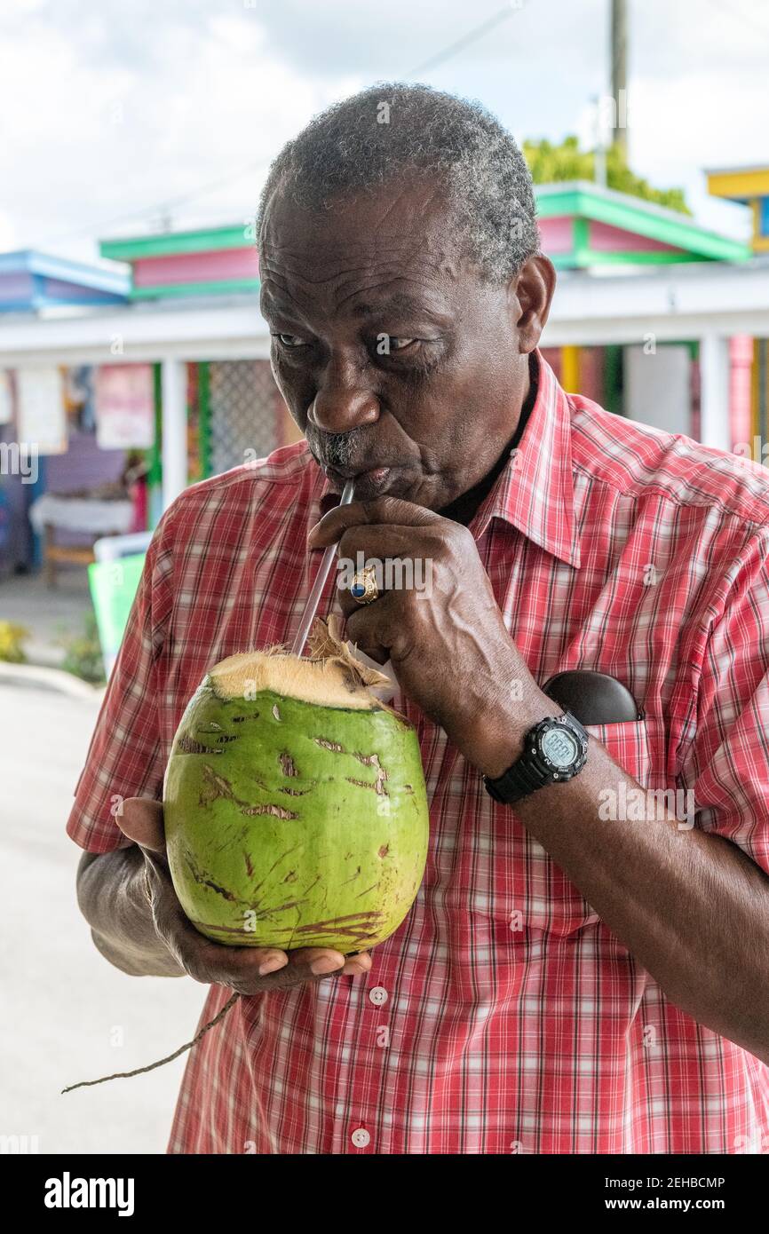 Afro-Caribbean man drinking water from a coconut, Freeport, Bahamas, 2019 Stock Photo