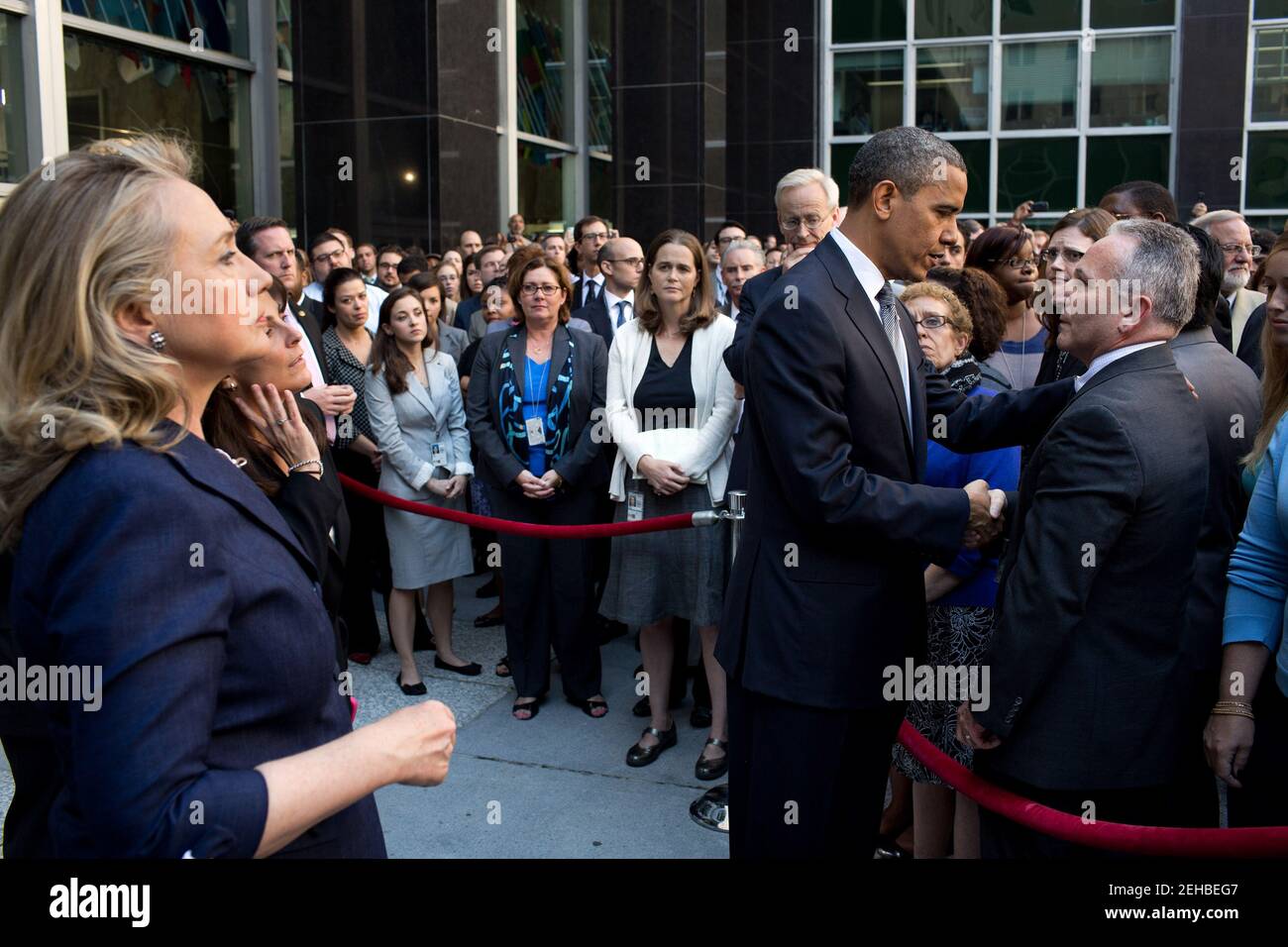 President Barack Obama greets State Department employees after speaking to them in a courtyard at the State Department in Washington, D.C., Sept. 12, 2012. Secretary of State Hillary Rodham Clinton stands at left. The President made the visit after Chris Stevens, U.S. Ambassador to Libya, and three others were killed at the consulate in Benghazi, Libya, yesterday. Stock Photo