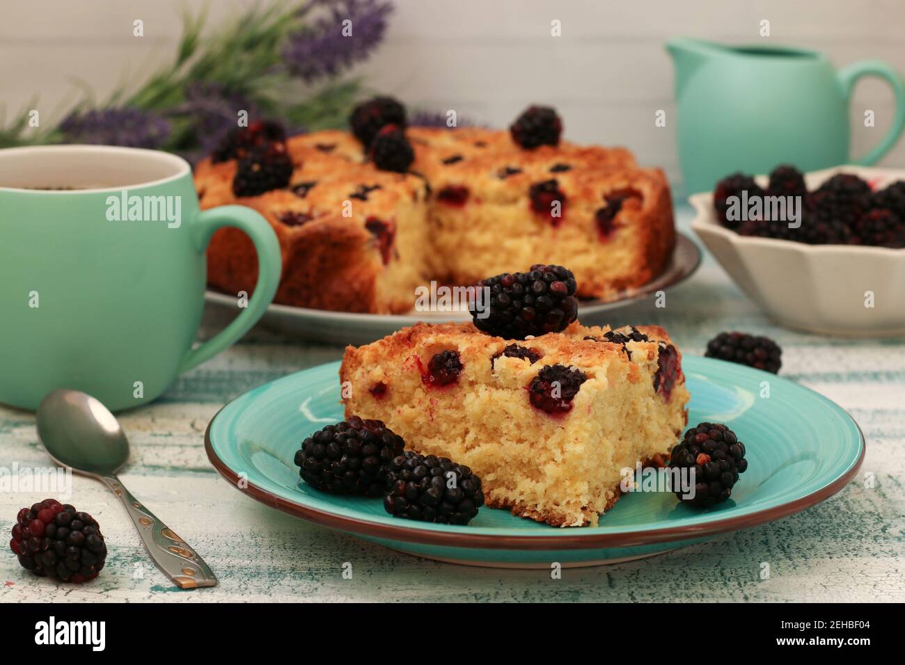 Piece homemade pie with blackberries and coconut chips on a light blue background. Closeup Stock Photo