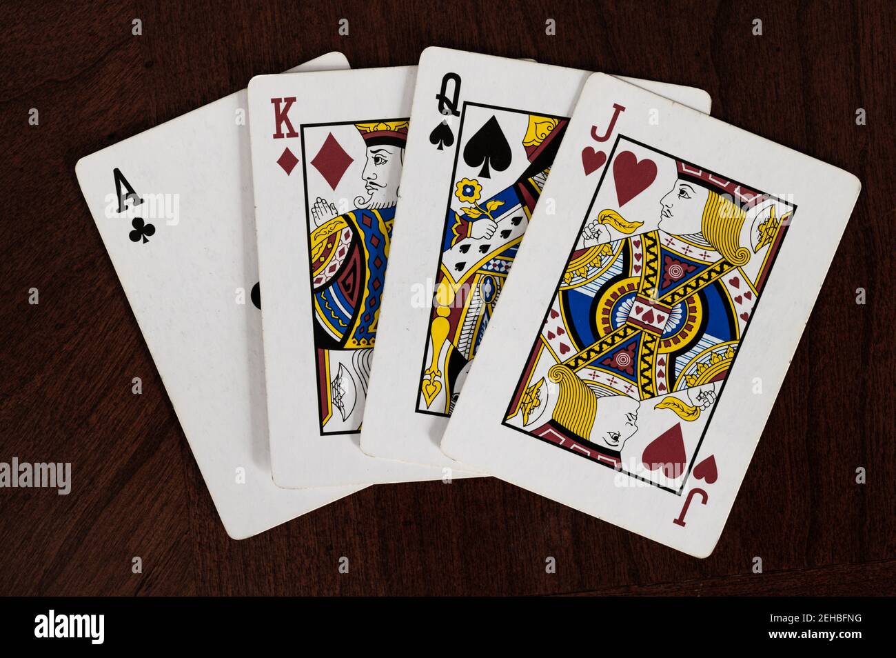 Ace of clubs, king of diamonds, queen of spades, and jack of hearts playing  cards on wood table Stock Photo - Alamy