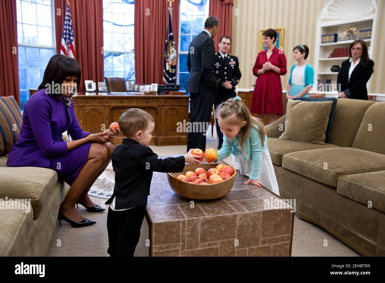 President Barack Obama and First Lady Michelle Obama visit with former Staff Sergeant Clinton Romesha and his family in the Oval Office prior to a ceremony to award Romesha the Medal of Honor, Feb. 11, 2013.  Remesha's family members, from left, are: son Colin Romesha, 2; daughter Gwen Romesha, 4;  wife Tammy Romesha, daughter Dessi Romesha, 11; and mother Tish Rogers. Stock Photo