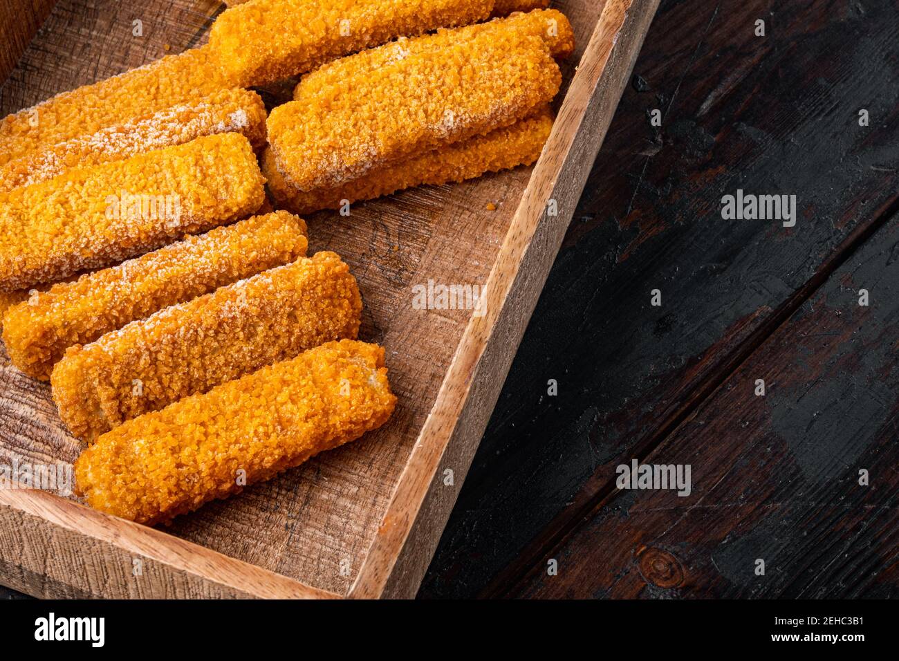 Frozen fish fingers set, in wooden box, on old dark wooden table background  , with copyspace and space for text Stock Photo - Alamy