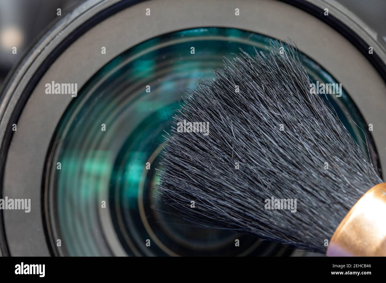 A cleaning camera lens with soft brush, close up view. Stock Photo