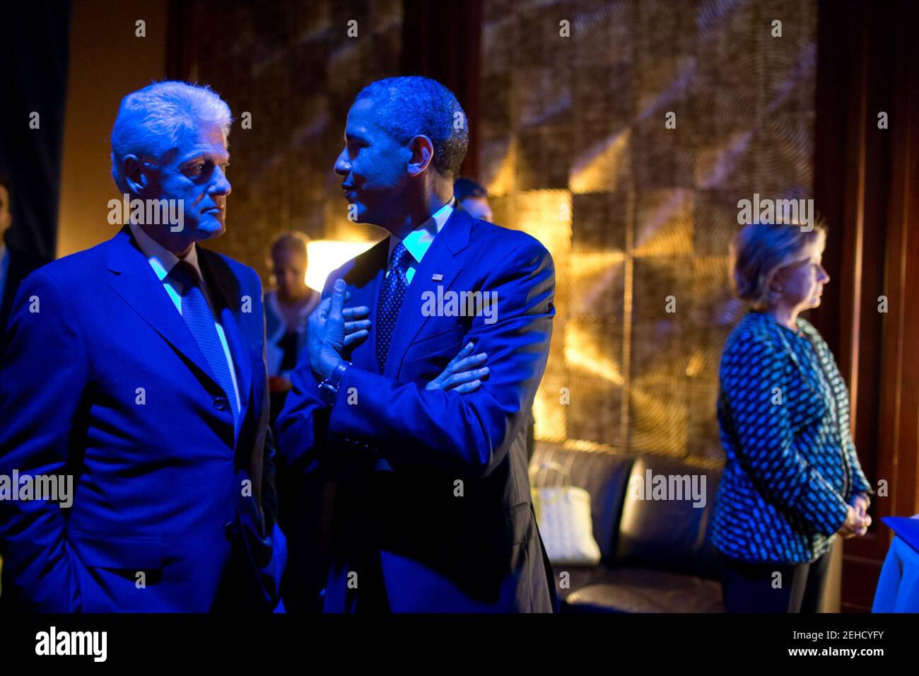Sept. 24, 2013 'The President and former President Bill Clinton are bathed in blue light as they talk backstage prior to participating in the Clinton Global Initiative Healthcare Forum in New York City. Former Secretary of State Hillary Rodham Clinton, right, waits to introduce them.' Stock Photo
