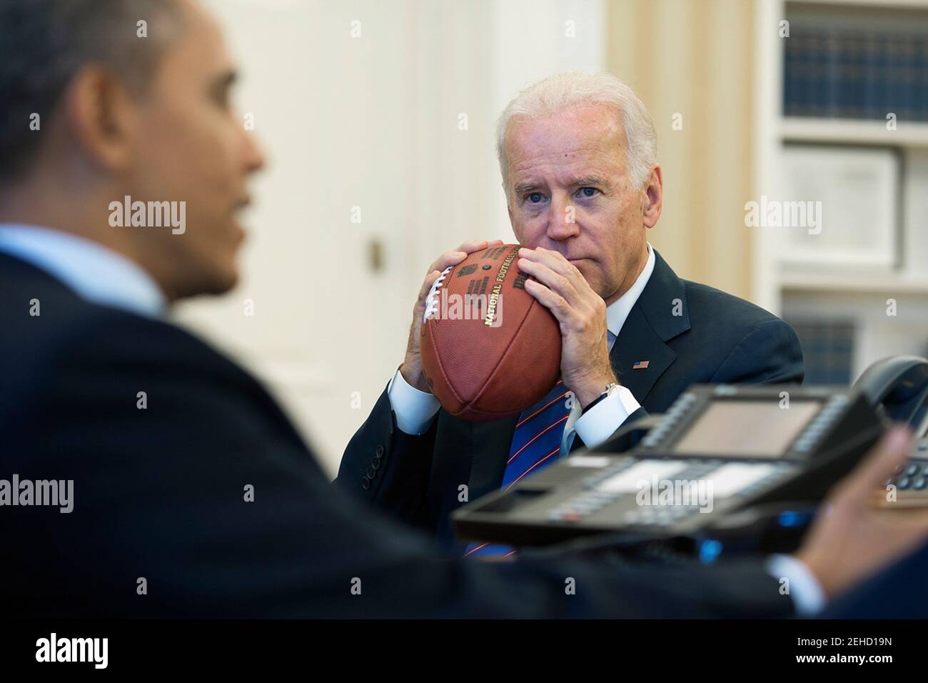 President Barack Obama, with Vice President Joe Biden, conducts a conference call with Rob Nabors, Deputy Chief of Staff for Policy, and Senate Majority Leader Harry Reid to discuss the federal government shutdown and debt ceiling, in the Oval Office, Oct. 15, 2013. Stock Photo