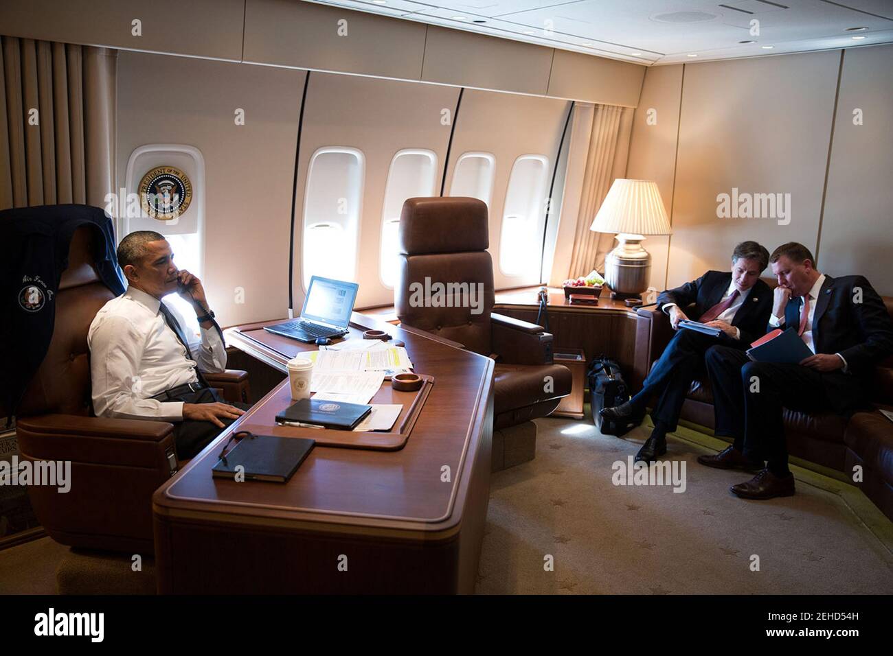 President Barack Obama talks on the phone with Israeli Prime Minister Benjamin Netanyahu aboard Air Force One en route to New Orleans, La., Nov. 8, 2013. Seated at right are Tony Blinken, Deputy National Security Advisor, and Trip Director Marvin Nicholson. Stock Photo