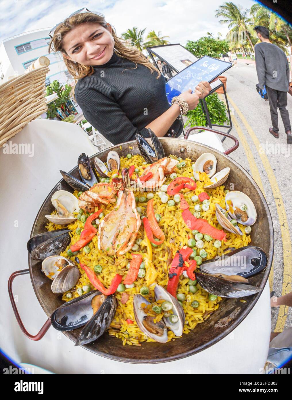Miami Beach Florida,South Beach,Ocean Drive,fisheye lens restaurant hostess holding clams mussels paella, Stock Photo