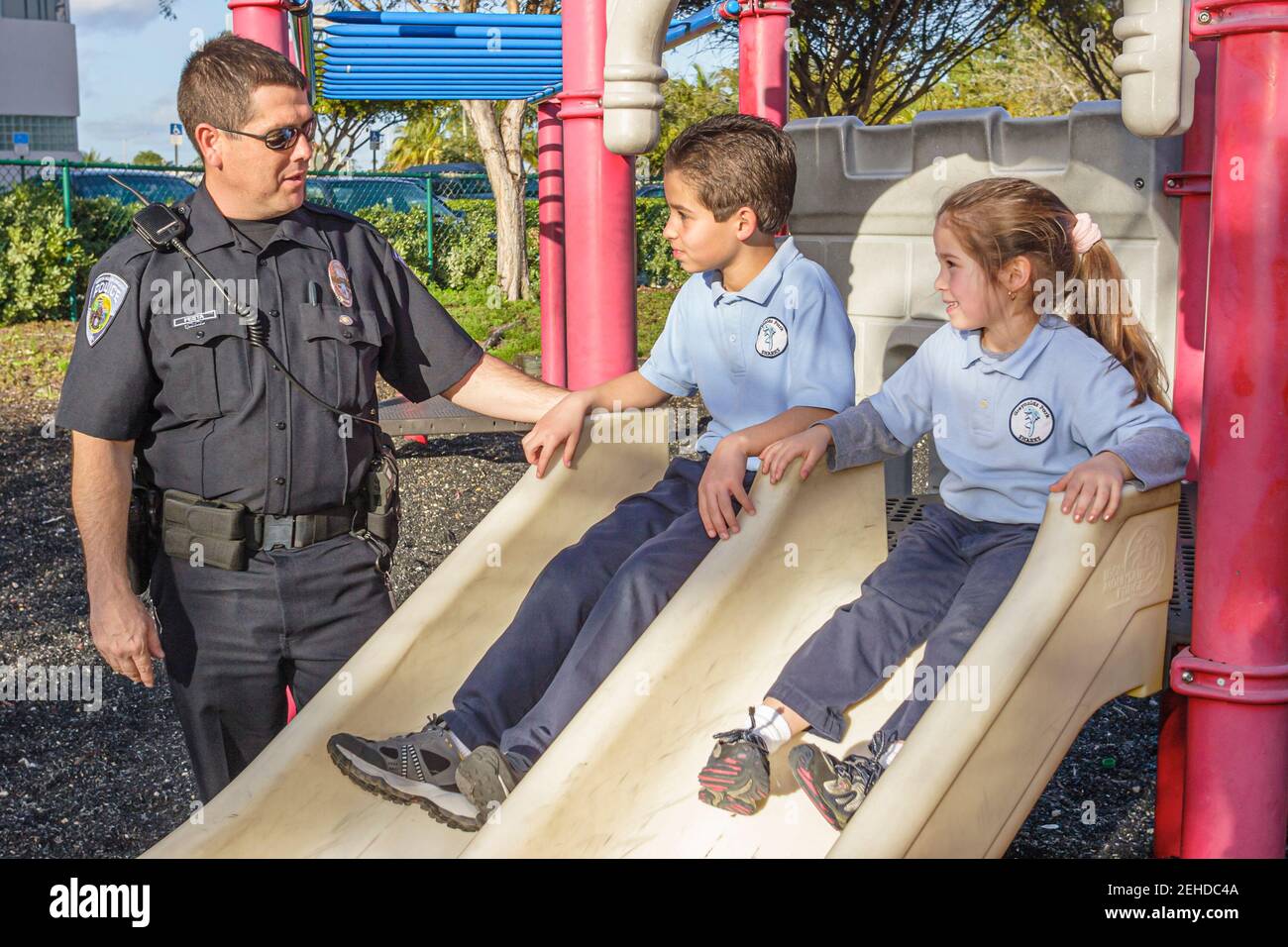 North Miami Beach Florida,Police Department,policeman,Hispanic boy girl playground slide, Stock Photo