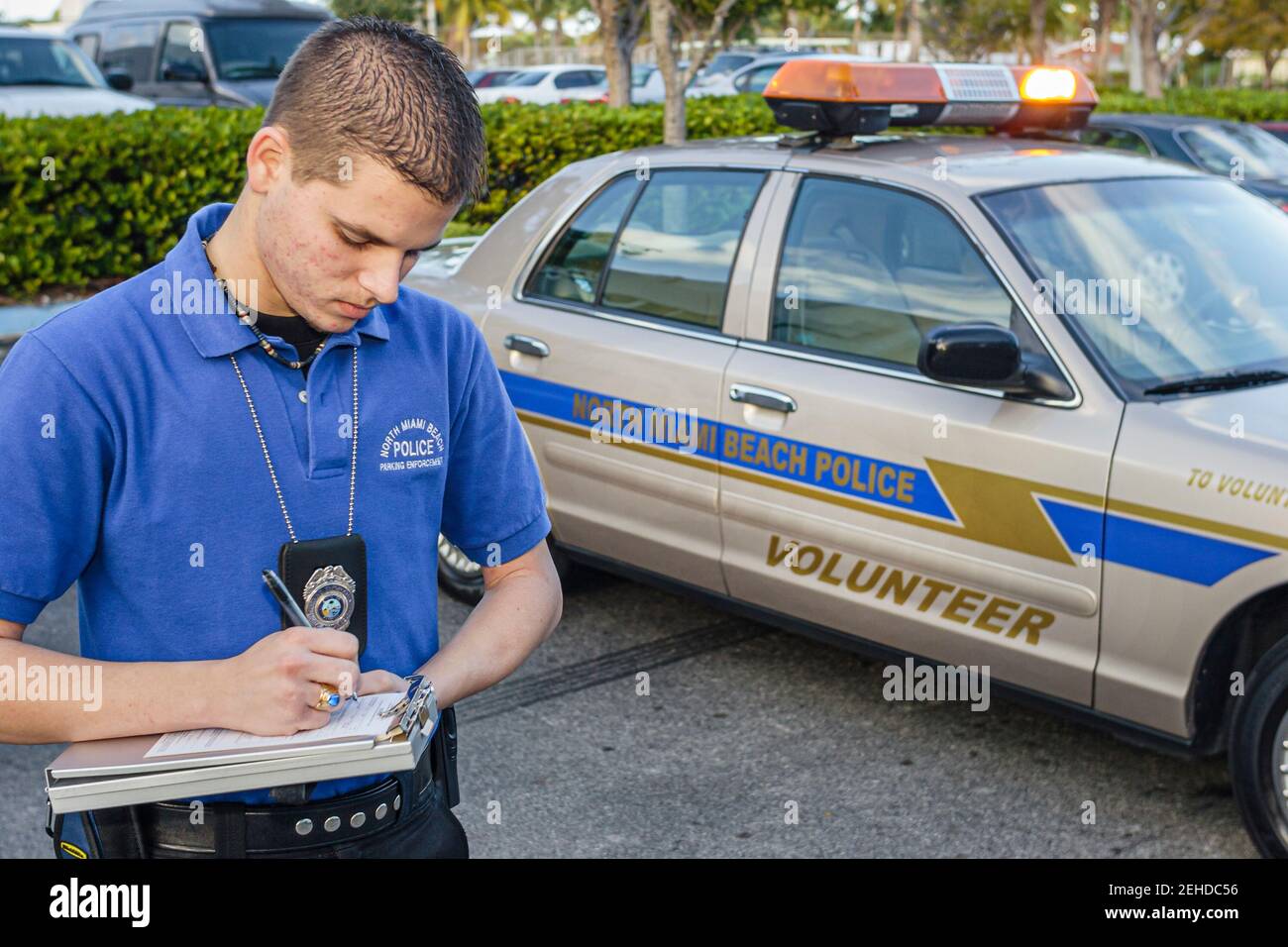North Miami Beach Florida,Police Department,Hispanic man volunteer parking enforcement writes writing ticket, Stock Photo