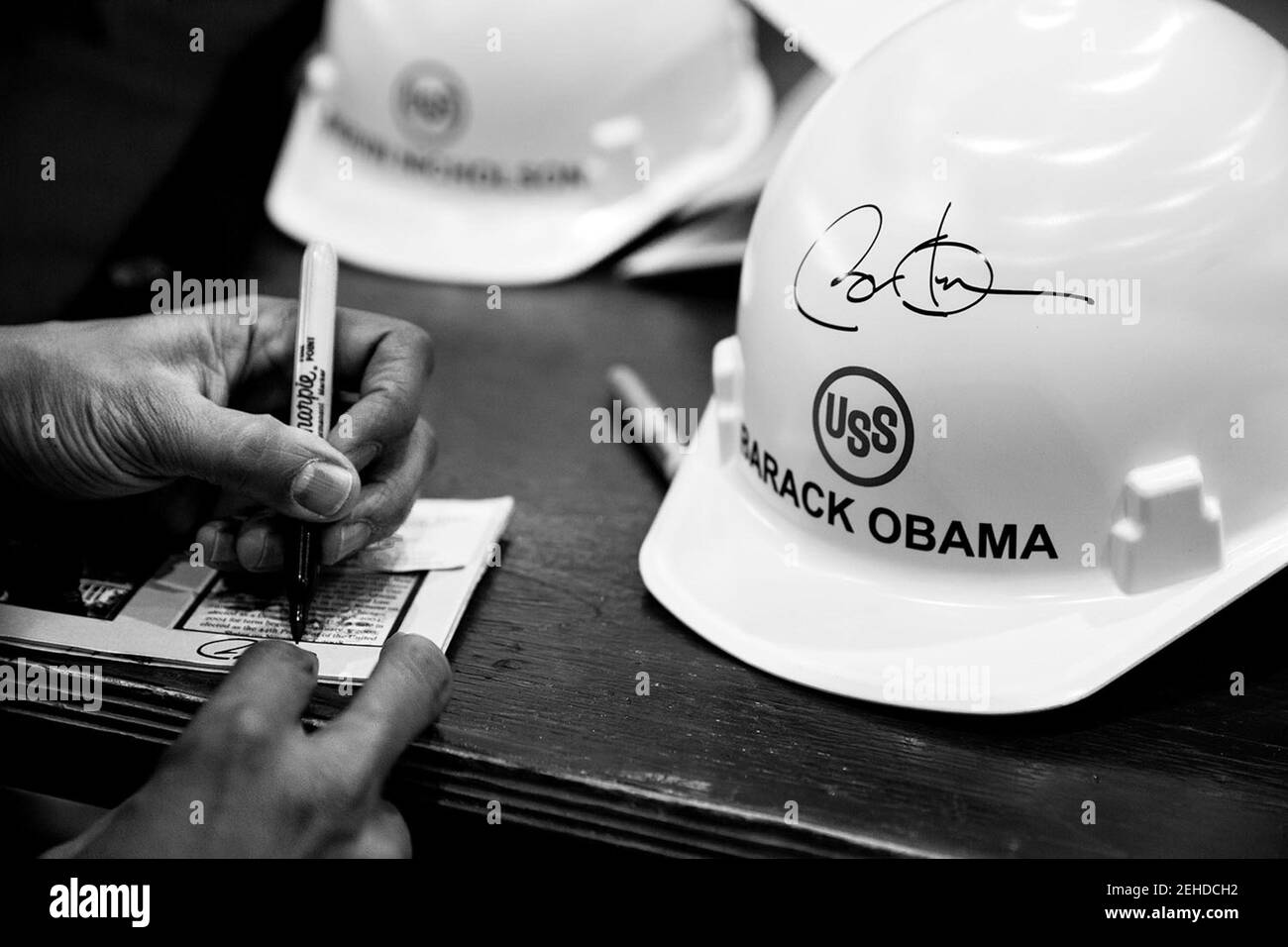 President Barack Obama signs hard hats and other items after delivering remarks at the United States Steel Corporation Irvin Plant in West Mifflin, Penn., Jan. 29, 2014. Stock Photo