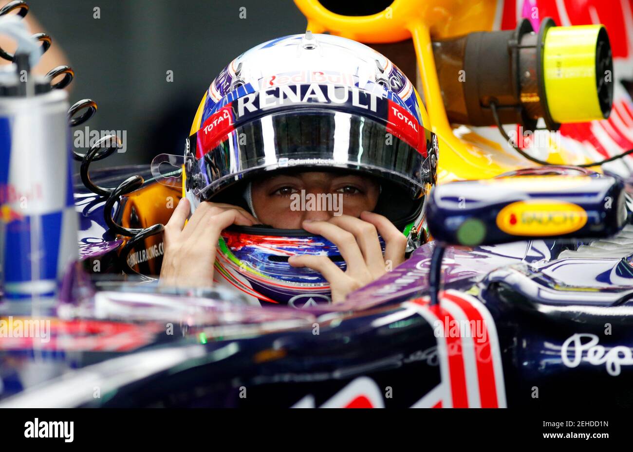 Formula One - F1 - Malaysian Grand Prix 2015 - Sepang International Circuit, Kuala Lumpur, Malaysia - 27/3/15  Red Bull's Daniel Ricciardo adjusts his helmet in the pit during practice  Reuters / Olivia Harris  Livepic Stock Photo