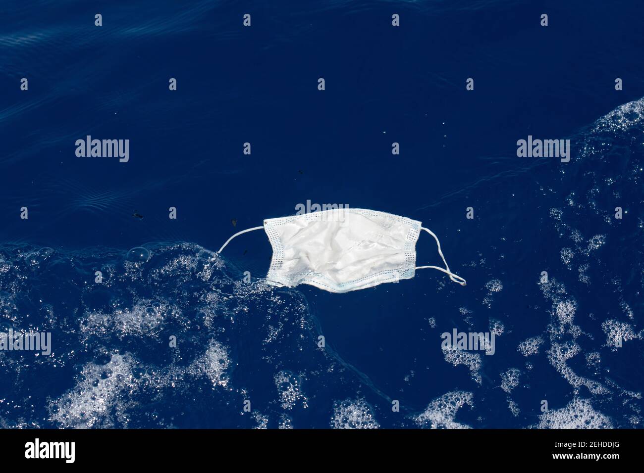 discarded surgical face mask floating in the ocean during the 2020-2021 covid-19 pandemic has become marine debris, Kohala, Hawaii, USA ( Pacific ) Stock Photo