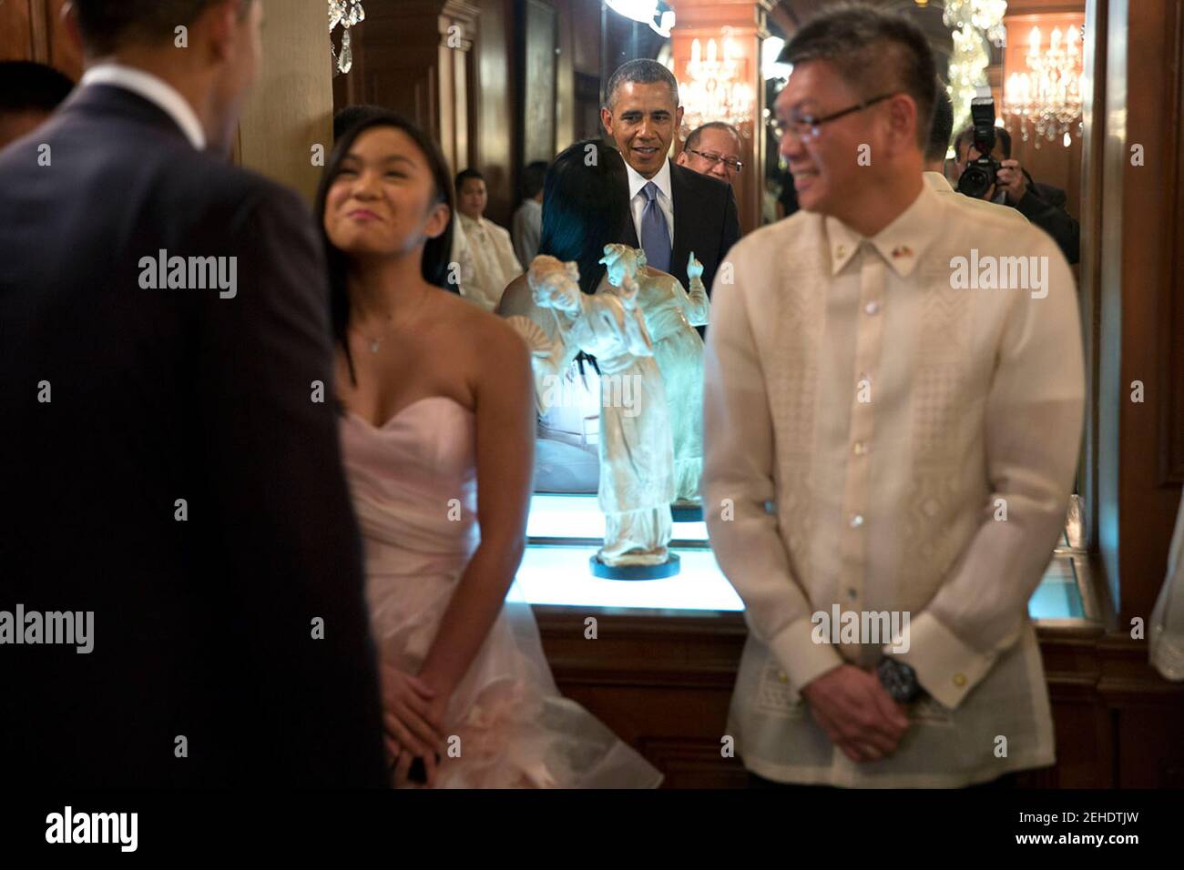 President Barack Obama and President Benigno S. Aquino III  are reflected in a mirror as they greet members of the Aquino family prior to a state dinner at the Malacañang Palace in Manila, Philippines, April 28, 2014. Stock Photo