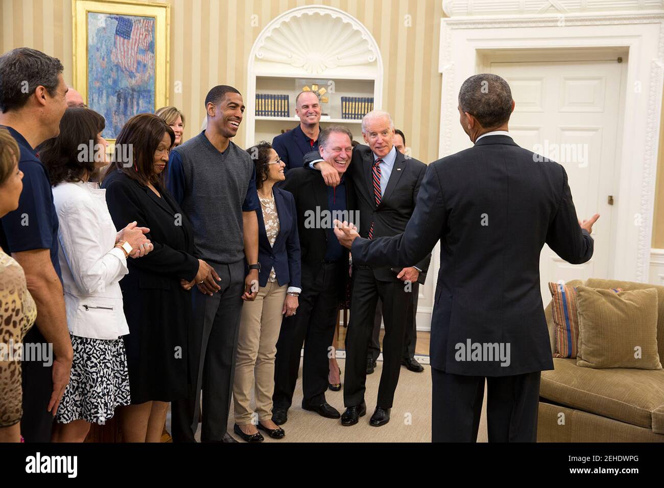 President Barack Obama and Vice President Joe Biden joke with Michigan State head basketball coach Tom Izzo and other  'Hoops for Troops' Leadership seminar participants  during a visit to the Oval Office, May 7, 2014. Stock Photo
