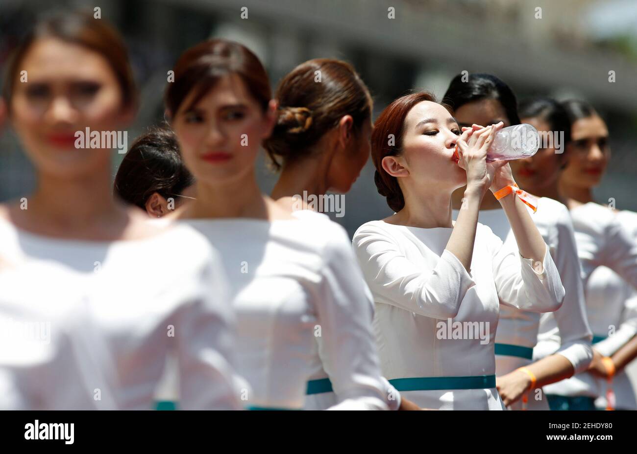 Formula One - F1 - Malaysian Grand Prix 2015 - Sepang International Circuit, Kuala Lumpur, Malaysia - 29/3/15  A pit lane girl takes a drink of water before the race  Reuters / Olivia Harris  Livepic Stock Photo
