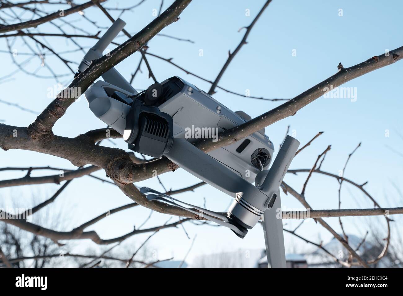 Broken gimbal camera and drone motor arm after crash on tree branches closeup Stock Photo