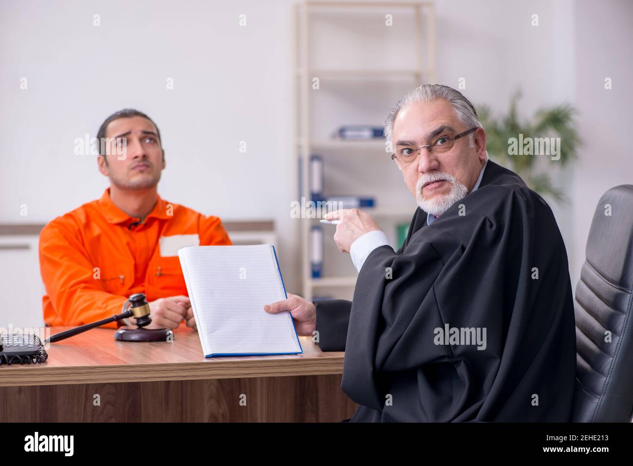 Old judge meeting with young captive in courthouse Stock Photo
