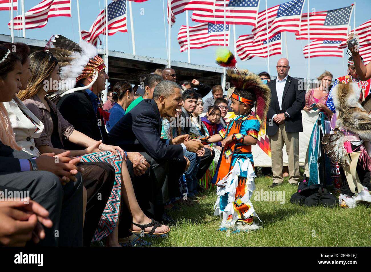 President Barack Obama, with First Lady Michelle Obama, greets a young boy during the Cannon Ball Flag Day Celebration at the Cannon Ball powwow grounds during a visit to the Standing Rock Sioux Tribe Reservation in Cannon Ball, N.D., June 13, 2014. Stock Photo