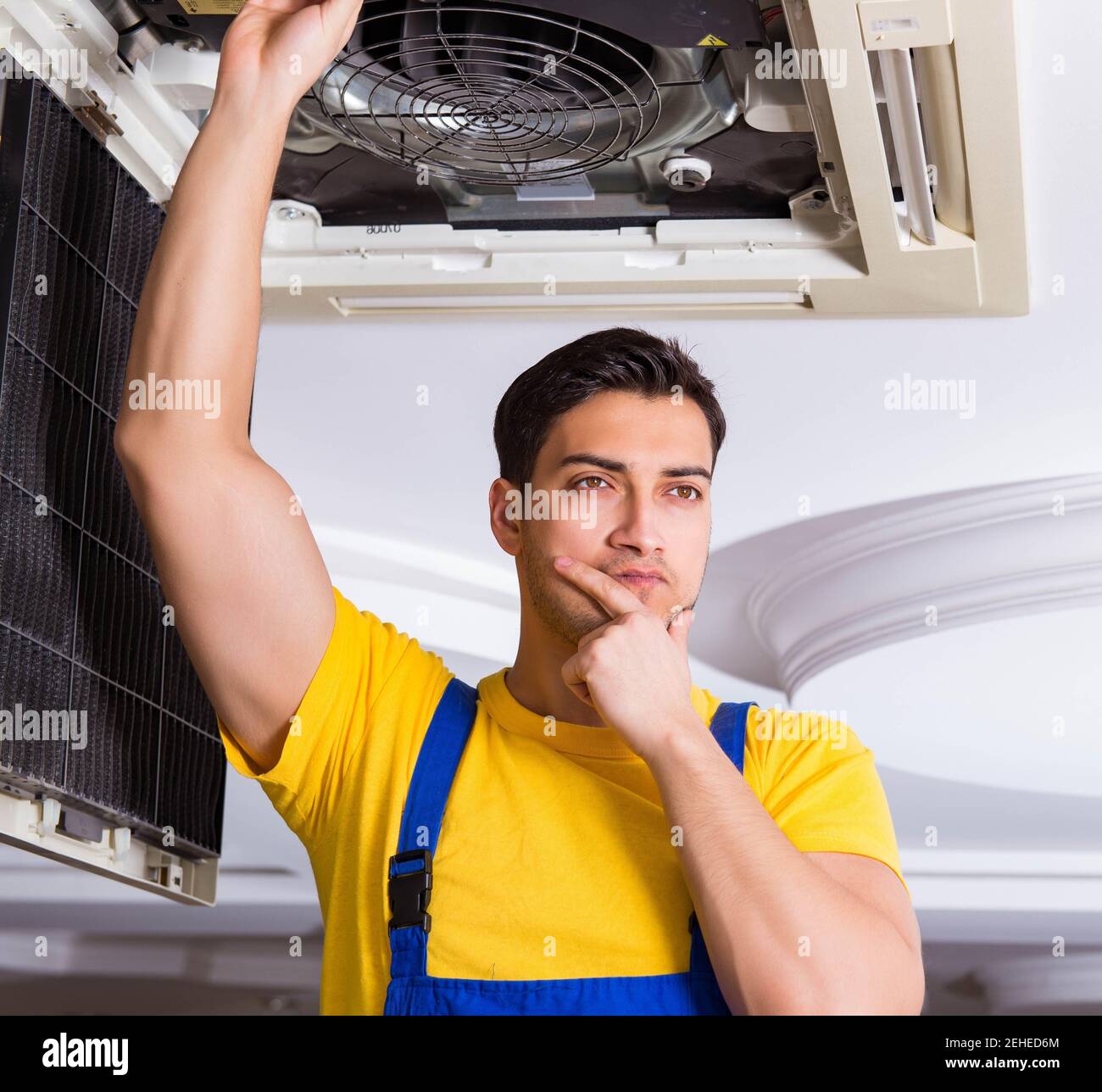 The repairman repairing ceiling air conditioning unit Stock Photo Alamy