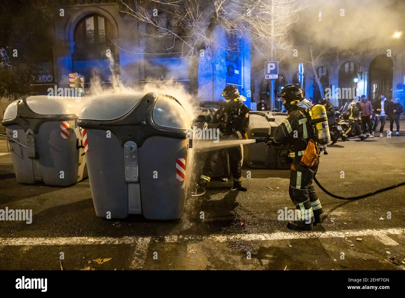 Barcelona, Spain. 19th Feb, 2021. Firefighters putting out one of the barricades on Comerçe Street during the fourth night of protests and riots in response to the arrest and imprisonment of rapper, Pablo Hasel accused of exalting terrorism and insulting the crown from the content of the lyrics of his songs. Credit: SOPA Images Limited/Alamy Live News Stock Photo